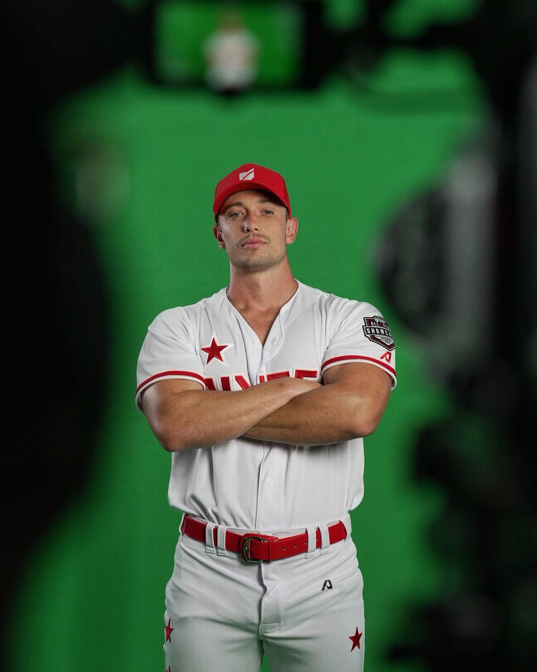 Chris in baseball uniform, arms crossed